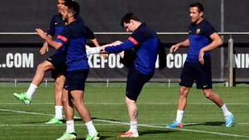 Lionel Messi (centro) realiza ejercicios durante la práctica de ayer con otros integrantes del Barcelona.