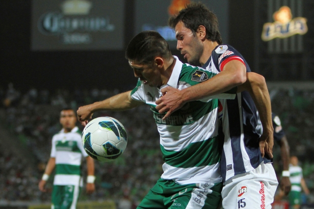 Oribe Peralta (izq.) de Santos, protege el esférico ante la marca de José María Basanta de Monterrey, durante el juego de ida de la final de Concacaf.