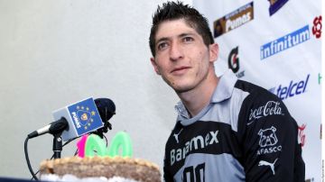 Alejandro Palacios habla con la prensa junto al pastel que recibió por los 100 juegos que cumplirá con los Pumas el domingo.