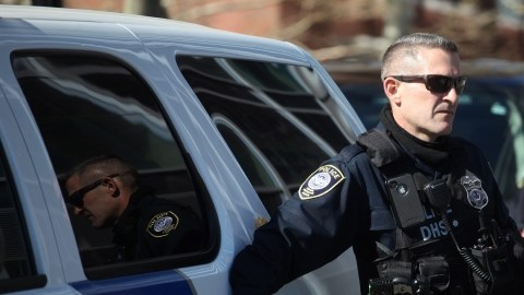 Un oficial del Departamento de Seguridad Nacional vigila afuera de una Corte Federal después de que tres sujetos fueran acusados de obstrucción a la justicia ayer en Boston, Massachusetts.