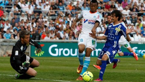 El gahanés Jordan J.Ayewy del Marsella contra el portero del Bastia, Mickael Landreau.