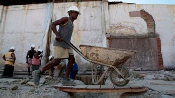 Trabajadores reparan una casa en Santiago de Cuba.