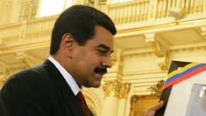 Cristina Fernández (d), recibiendo una fotografía del fallecido presidente Hugo Chávez, de su par venezolano, Nicolás Maduro (i).