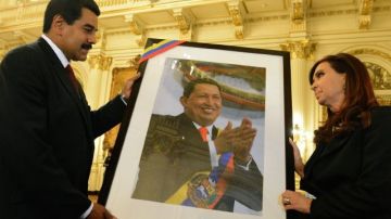 Cristina Fernández (d), recibiendo una fotografía del fallecido presidente Hugo Chávez, de su par venezolano, Nicolás Maduro (i).