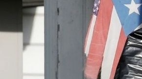 El FBI recoge pruebas de la casa de Castro y fuera se puede ver la bandera de Puerto Rico.