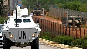 Cascos azules  en un vehículo blindado de transporte de personal de la ONU patrullan la frontera libanesa y los israelíes están en  la frontera libanesa-israeli.