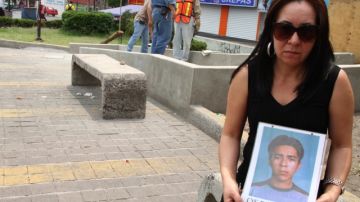Ana Enamorado sostiene la foto hijo Oscar. Ella cree que él está vivo pero que lo tienen haciendo trabajo forzado.