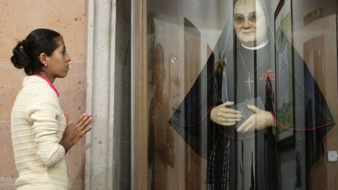 Una mujer ora en Guadalajara, México, ante la imagen de la Madre Lupita.