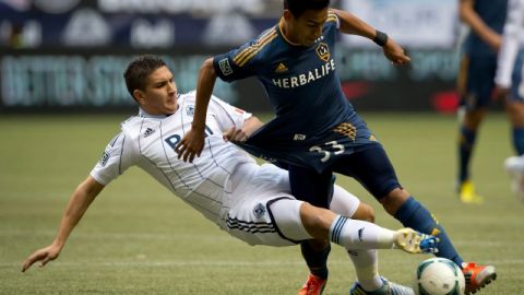 Vancouver Whitecaps' Johnny Leveron, left, of Honduras, takes down Los Angeles Galaxy's Jose Villarreal   in Vancouver, British Columbia.
