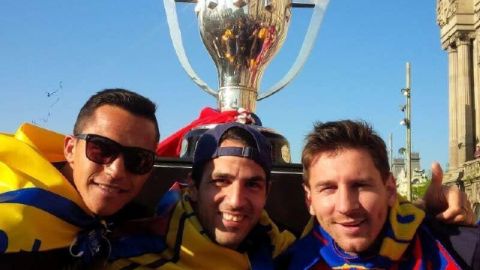 Lionel Messi (der.) con Cesc Fábregas (izq.) y Alexis Sánchez en el desfile de ayer para celebrar el título.