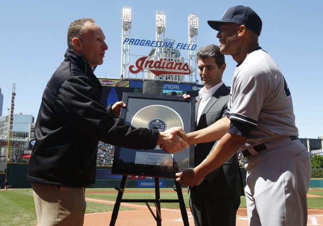 El presidente de los Indios, Mark Shapiro (i) y el presidente del museo de la fama del Rock and Roll, Greg Harris (c),  le entregan  a  Mariano Rivera (d), una réplica del disco 'Enter Sandman', la canción de entrada de Rivera a su ingreso en los juegos.