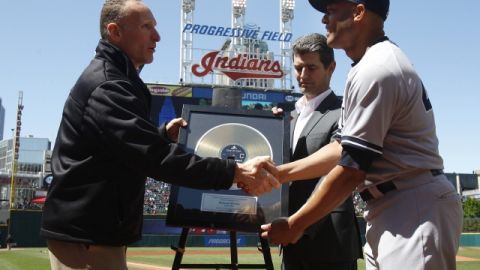 El presidente de los Indios, Mark Shapiro (i) y el presidente del museo de la fama del Rock and Roll, Greg Harris (c), le entregan a Mariano Rivera (d), una réplica del disco 'Enter Sandman', la canción de entrada de Rivera a su ingreso en los juegos.