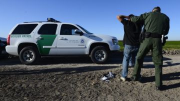 LWS102. MCALLEN (TX, EE.UU.), 25/02/2013.- Agentes de la patrulla fronteriza detienen a un presunto inmigrante ilegal en un costado del Río Grande hoy, martes 25 de febrero de 2013, cerca de McAllen, Texas (EE.UU.). La frontera entre Estados Unidos y México, de unos 3200 kilómetros de largo, es considerada la más transitada del mundo. EFE/Larry W. Smith