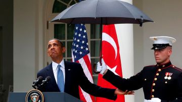 El presidente Barack Obama se resguarda de la lluvia durante una rueda de prensa este jueves en los jardines de la Casa Blanca.