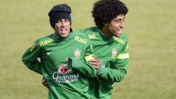 Neymar (izq.), aquí jugueteando con Dante en un entrenamiento con Brasil, podría ver empedrado el camino rumbo al futbol de España.