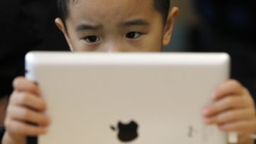 Un niño  observa una tableta Ipad  en la recién abierta tienda de Apple en el distrito comercial de Wangfujing en Pekín (China).