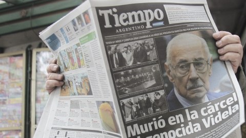 Un hombre lee un diario con la noticia de la muerte del exdictador Videla.