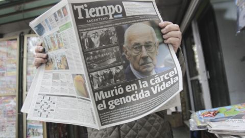 Un hombre lee un diario con la noticia de la muerte del exdictador Videla.