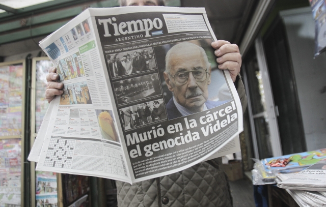 Un hombre lee un diario con la noticia de la muerte del exdictador Videla.