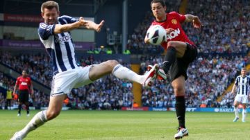 Javier 'Chicharito' Hernández (der.) del Manchester United, patea el balón ante  Gareth McAuley  del West Bromwich Albion. El juego terminó empatado 5-5.