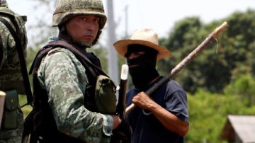Un soldado junto a un miembro de un grupo de autodefensa local en Buenavista, Michoacán, México. Los residentes han tomado las armas para defender su comunidad contra las bandas de narcotraficantes.