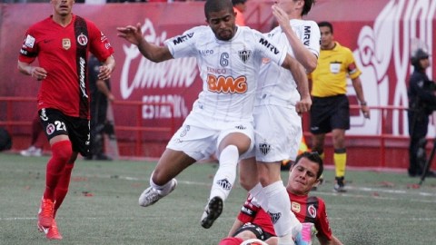 Juan Carlos Núñez, de Xolos, intenta frenar a Junior Machado, del Mineiro, en duelo de ida de cuartos de final de la Copa Libertadores.