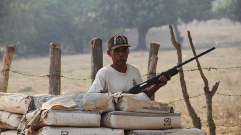 Un guardia de seguridad detrás de un retén de vigilancia entre la carretera que conecta a dos municipios de Florencio Villarreal, estado de Guerrero.