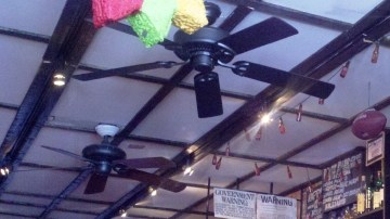 Jorge Villegas, gerente de Mojitos, muestra una de las multas que le dio NYPD al negocio. En el círculo, detalle de una penalidad por no exhibir su certificación.