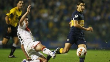 Nicolás Blandi (d) de Boca disputa el balón  ante Pablo Pérez (i) de Newells Old Boys, durante el juego de ida de cuartos de final de la Copa Libertadores.