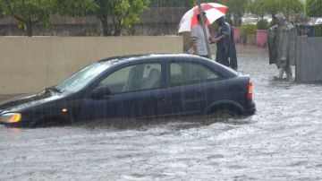 Una persona intenta rescatar su vehículo en las inundaciones causadas por el huracán  "Bárbara" en el puerto de Acapulco, estado de Guerrero, en el sur de México.