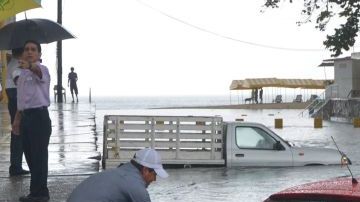 Una persona intenta rescatar su vehículo hoy en las inundaciones del puerto de Acapulco, estado mexicano de Guerrero, causadas por "Bárbara".