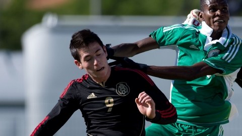 El jugador mexicano Marco Bueno (izq.) lucha con un defensa y el portero de Nigeria en el juego de ayer.