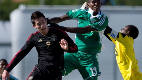 El jugador mexicano Marco Bueno (izq.) lucha con un defensa y el portero de Nigeria en el juego de ayer.