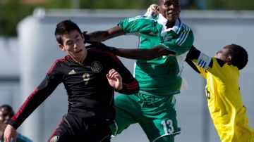 El jugador mexicano Marco Bueno (izq.) lucha con un defensa y el portero de Nigeria en el juego de ayer.