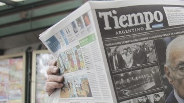 Un hombre lee un diario con la noticia de la muerte del exdictador Videla.