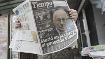 Un hombre lee un diario con la noticia de la muerte del exdictador Videla.