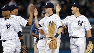 Jugadores de los Yankees (desde la izquierda), Robinson Cano, Mariano Rivera, Reid Brignac, y Mark Texeira celebran la victoria de su equipo sobre los Indios.