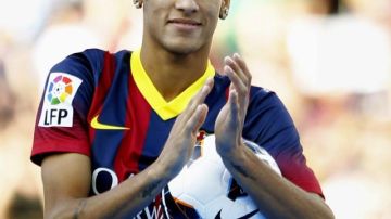 Neymar aplaude a los aficionados en su presentación como nuevo jugador del Barcelona.