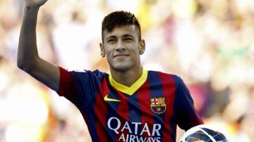 El joven delantero brasileño Neymar da Silva saluda a la afición durante su presentación oficial en el Camp Nou como nuevo jugador de Barcelona.