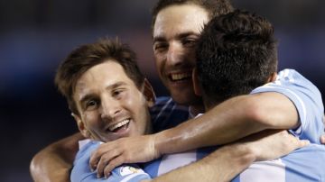 Lionel Messi se abraza con sus compañeros Gonzalo Higuaín y Sergio Agüero (de espaldas). Argentina tiene dos compromisos difíciles ante Colombia y Ecuador.