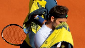 La tristeza de Roger Federer (al frente) se ve reflejada en su rostro, mientras que Jo Wilfried Tsonga va camino a las semifinales del Abierto de Francia.