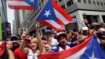 Revelers line the route of the National Puerto Rican Day Parade on New York's Fifth Ave.,  Sunday, June 10, 2012. The parade has been an annual event in New York since 1958 and has grown to be one of the city's largest. (AP Photo/Richard Drew)