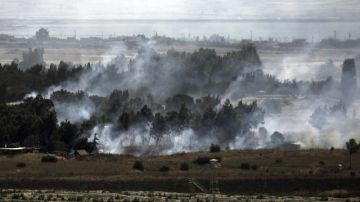 El humo revela los enfrentamientos entre los rebeldes y el ejército sirio cerca de la frontera israelí con Siria en los Altos del Golán.