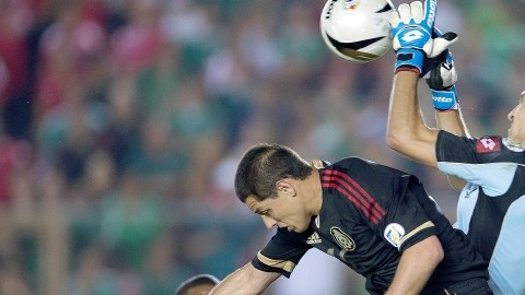 'Chicharito' no puede rematar a su antojo ante el portero Jaime Penedo, quien ataja el balón en el Rommel Fernández.