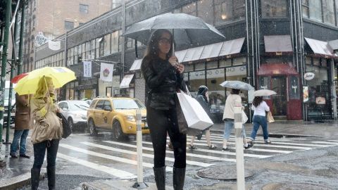 Dos mujeres esperan el bus en SoHo bajo un aguacero.