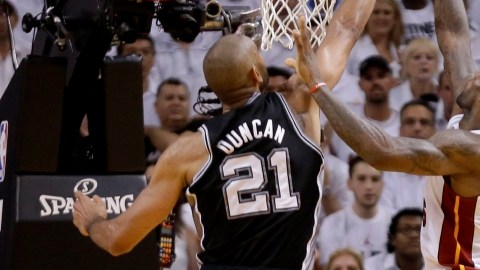 LeBron James (d), la estrella del Miami Heat, trata de encestar ante la defensa de Tim Duncan, el referente de los Spurs de San Antonio, en el primer partido de las finales de la NBA.