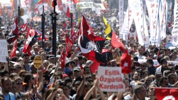 Un grupo de manifestantes agitan banderas turcas y pancartas durante una protesta ayer en la plaza Taksim.