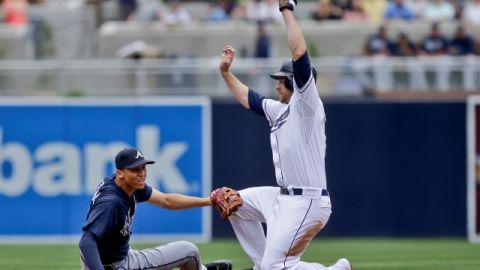 El jugador de los Padres de San Diego, Chase Headley llega quieto a la segunda base al esquivar el guante del parador en corto de los Bravos de Atlanta, Andrelton Simmons.