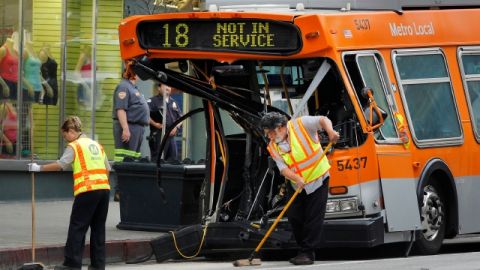 Trabajadores de la Autoridad de Tránsito Metropolitano limpian la calle luego del accidente, ayer en el centro de Los Ángeles.