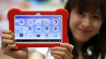 Una azafata muestra la tableta infantil "Tap me" de MegaHouse Corp. durante la inauguración ayer  de la Feria del Juguete de Tokio, Japón.